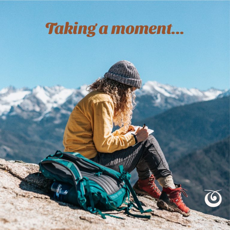 woman sitting in the mountains journalling